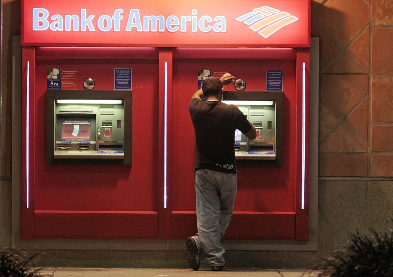 SO MUCH FOR THAT: A Bank of America customer is shown recently at an ATM in Hialeah, Fla. The bank is scrapping its plans to charge a $5 monthly debit card fee after an uproar of customer outrage in recent weeks.