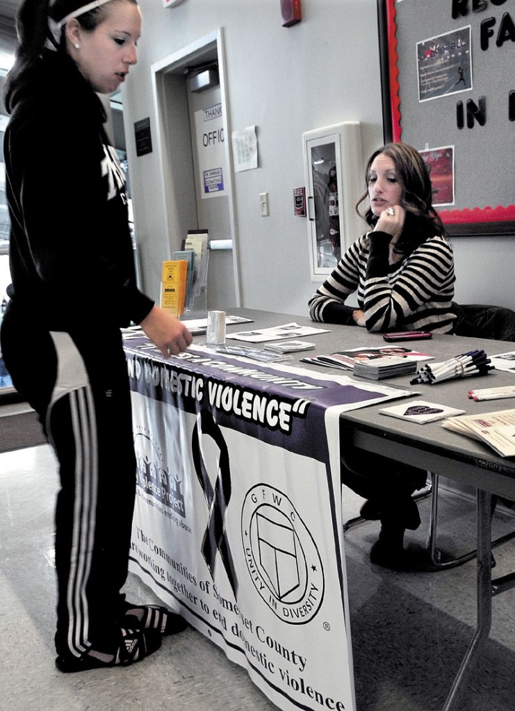 IMPORTANT ISSUE: Heidi Olson, right, a volunteer with the Family Violence Project, answers questions from Elizabeth Goodall during the Taylor Tip Off basketball tournament at Thomas College in Waterville on Sunday. The event helps raise awareness of domestic violence.