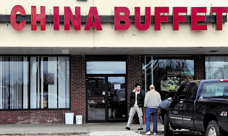 VISITORS: An employee at the Super China Buffet restaurant in Waterville, left, speaks with another man shortly after U.S. Immigration and Customs Enforcement agents reportedly checked employees on Wednesday to ensure they are legally in the country. The worker said the restaurant will be open today.