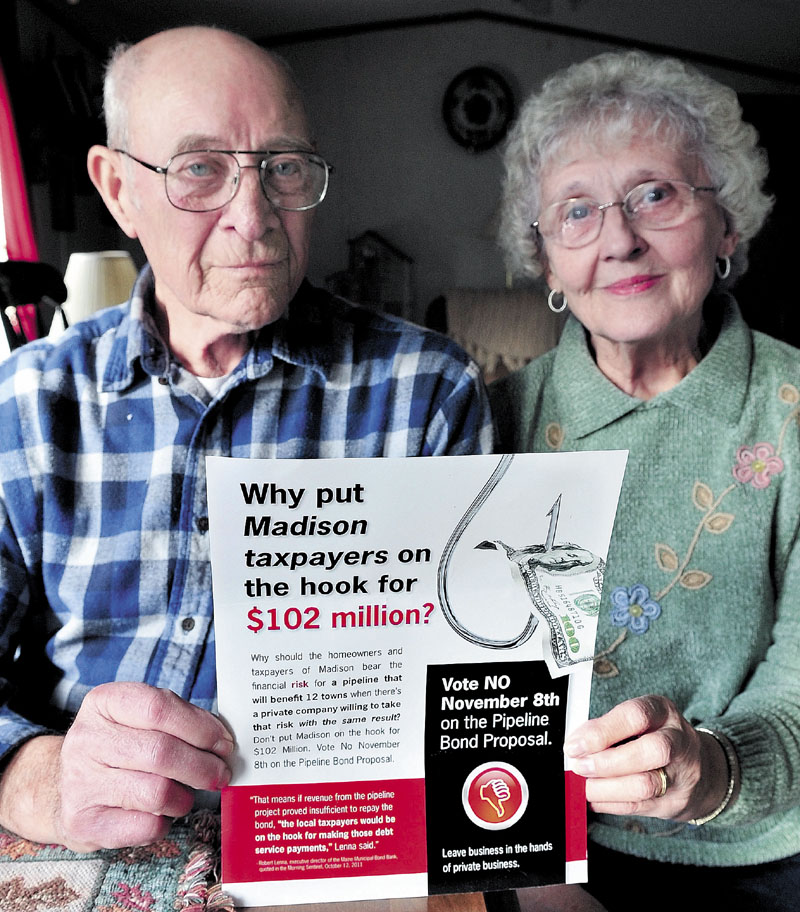 WHY NOT: Walter and Betty Thebarge of Madison hold a flier they received recently urging residents to vote against a town pipeline bond proposal. The couple said they will vote in favor of the proposal.