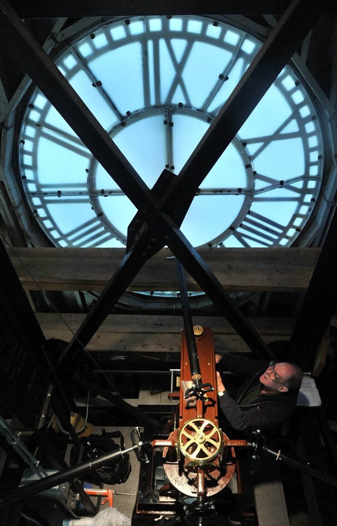 Staff photo by Michael G. Seamans perform the annual maintenance of the Miller Library clock tower at Colby College in Waterville Tuesday morning.