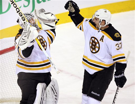 Boston Bruins goalie Tim Thomas (30) celebrates with teammate Patrice Bergeron after defeating the Montreal Canadiens 1-0 Monday in Montreal. Canada Quebec Montreal hockey NHL athlete athletes athletic athletics Canada Canadian competative compete competing competition competitions game games League National play player playing pro professional sport sporting sports team Montreal Canadiens Bell Center Centre Bell Toronto Maple L