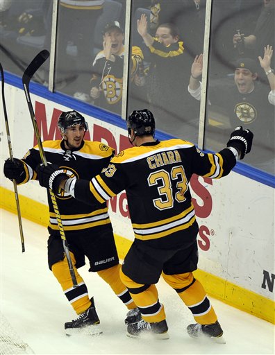 Boston Bruins' Brad Marchand (63) and Zdeno Chara (33) celebrate Chara's goal against New York Islanders goalie Anders Nilsson in the third period Saturday in Uniondale, N.Y. The Bruins won 6-0.