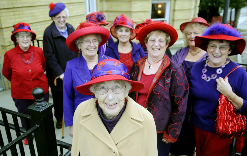 Charlotte Eastman, center, is surrounded Sunday by members of the Augusta Red Hat Society before attending a play at Hallowell City Hall. Eastman, 93, just penned an autobiography and attended the play to celebrate her birthday.