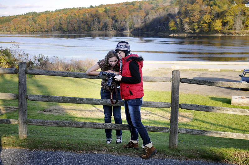 WILL THIS ONE DO? Caitlynn Stanley, left, inspects a photo Tuesday taken by Lisa Swanton, Brunswick, above the bulkhead on the Kennebec River in Hallowell. Stanley said she was a bit late to pose for senior portraits for the Maranacook Community High School yearbook, but still had nice weather for photos.