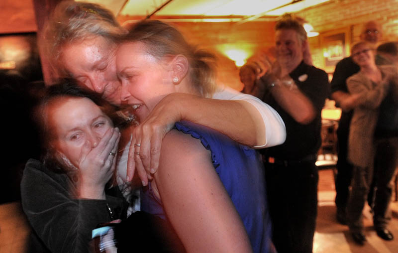 NEW MAYOR: Mayor-elect Karen Heck, center left, hugs her campaign manager, Dana Hernandez, left, and Megan Williams after poll results showed Heck had won the mayoral election during a celebration Tuesday night at 18 Below Raw Bar in Waterville.