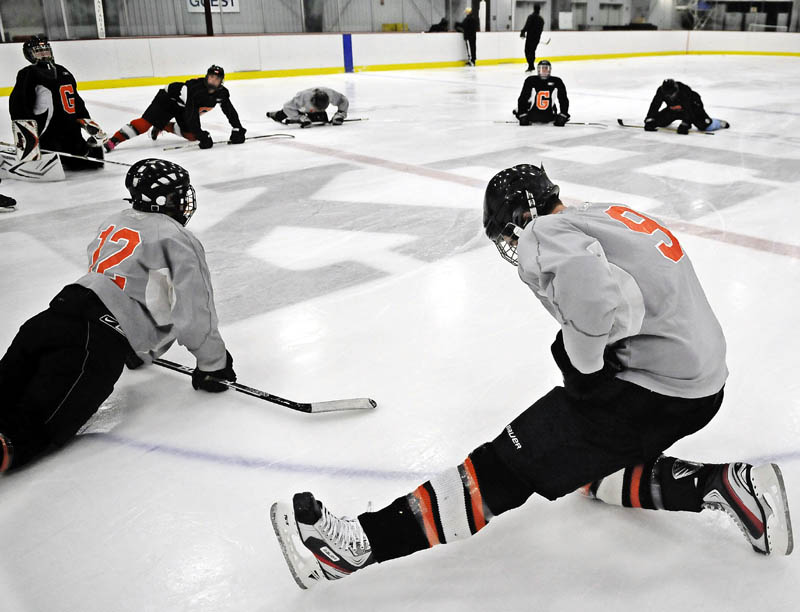 ICE TIME: Gardiner Area High School hockey players stretch Monday during the first practice of the season at Bonnefond Ice Arena at Kents Hill in Readfield. The Tigers open their season on the road against Maranacook/Hall-Dale/Winthrop on Dec. 9.