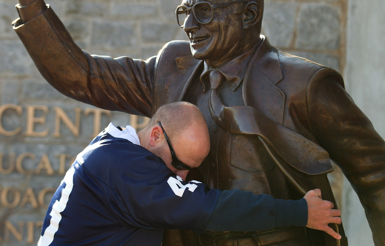 Penn State fan Gary Buck of West Grove, Pa., hugs a statue of former Penn State head coach Joe Paterno at Beaver Stadium before the football game between University of Nebraska and Penn State in State College, Pa., on Saturday.