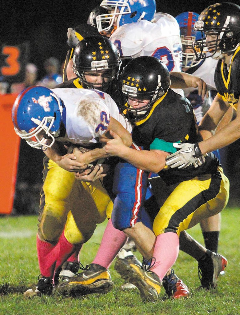 TEAMING UP: Maranacook Community High School's Tony McIver, top, helps George Bragdon, right, tackle Oak Hill High School running back Cody Depuy during a game earlier this year. The Black Bears will face Traip in the Campbell Conference Class C semifinals on Saturday.