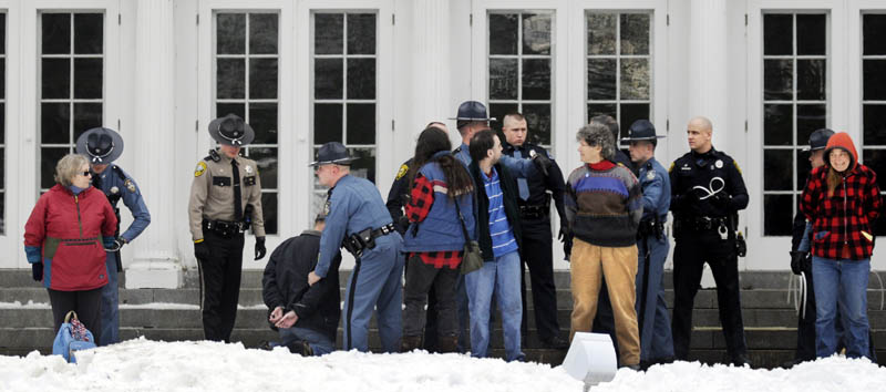CUFFED: Protesters are arrested Sunday on the lawn of the Blaine House during a rally by Occupy Augusta.