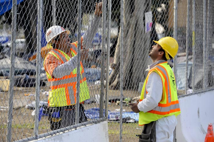 Public works employees erect a fence around Los Angeles City Hall park today.
