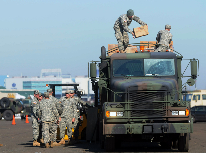 Members of the Connecticut National Guard Air Force and Army on Wednesday load pallets of MRE's (Made Ready to Eat) and bottled water onto a military truck to be shipped out to towns and communities affected by power outages.