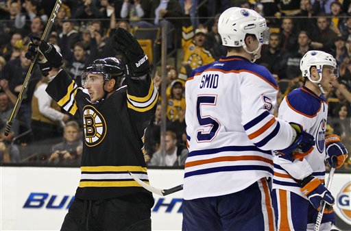 Boston Bruins left wing Brad Marchand, left, celebrates his goal against the Edmonton Oilers during the second period Thursday in Boston. At right are Oilers defensemen Ladislav Smid (5) and Corey Potter.