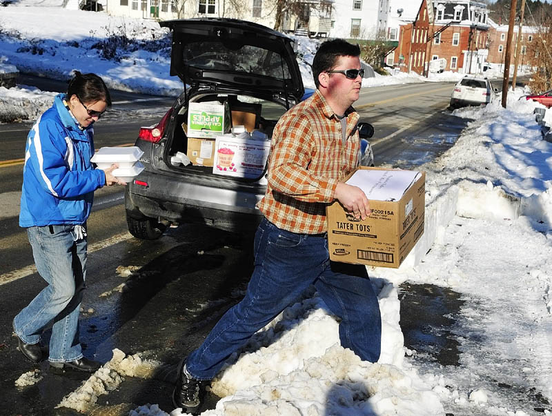 MEALS ON WHEELS: Erica Atkinson, left, and her husband Joshua Atkinson carry boxes of Thanksgiving dinners from their car to a Richmond home Thursday morning. They delivered 66 meals to the Richmond area.