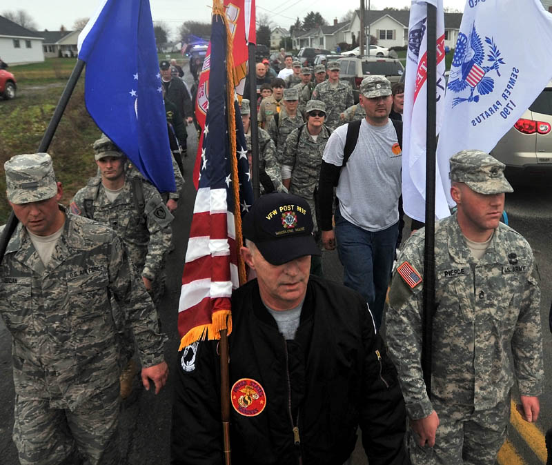 Staff photo by Michael G. Seamans Ronald Raymond, front center, leads a group of veterans to the Winslow Memorial Park as part of Veteran's Day memorial on Friday. The group marched 21 miles from the Vietnam Memorial in Augusta to Winslow.