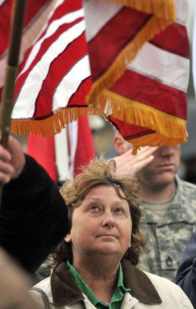 Staff photo by Michael G. Seamans Lorna Raymond watches the American flag during the playing of TAPs during a Veteran's Day ceremony at Memorial Park in Winslow Friday.