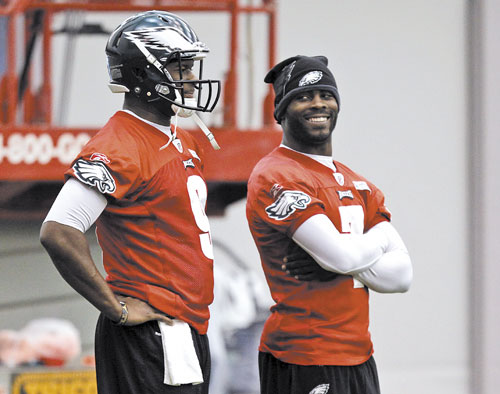 WHO’S IT GONNA BE? Philadelphia Eagles quarterback Vince Young, left, stands as quarterback Michael Vick smiles during an indoor practice Wednesday in Philadelphia. The Eagles have not said whether Young or Vick will start today against the Patriots.