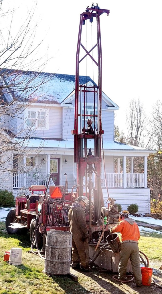 STILL DRILLING: Chris Palmer, left, and Chris Monroe, of East Coast Explorations, drill a bore hole in Peter Meulendyk’s front lawn on Wednesday in Manchester.