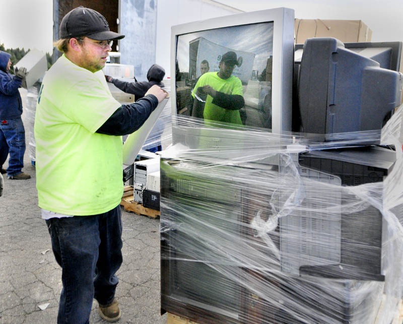eWaste Recycling Solutions employee Phillip Keller stretches plastic wrap around a pallet of televisions to hold them up during electronics recycling event on Saturday at the Augusta Civic Center.