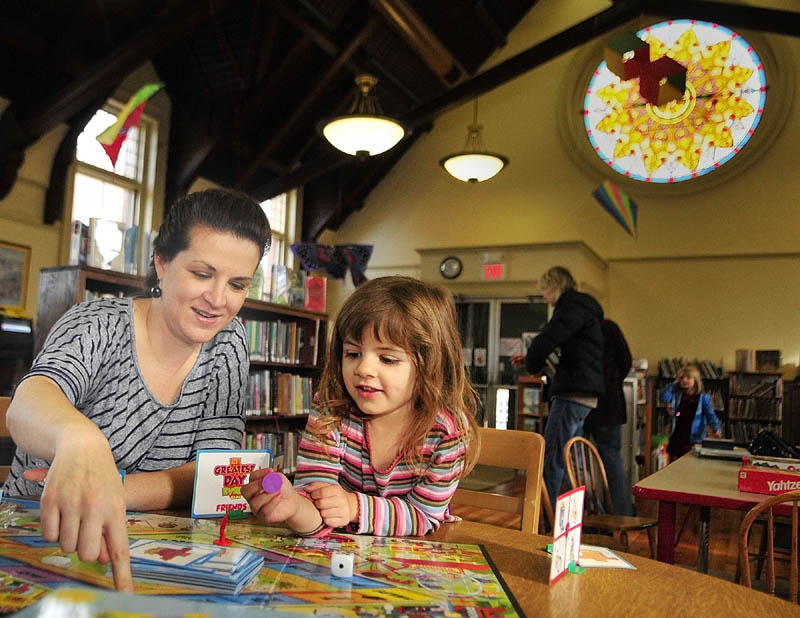 Laura Closson and her four-year-old daughter Kya Closson play a game in the Gardiner Public Library children's room on Saturday morning.