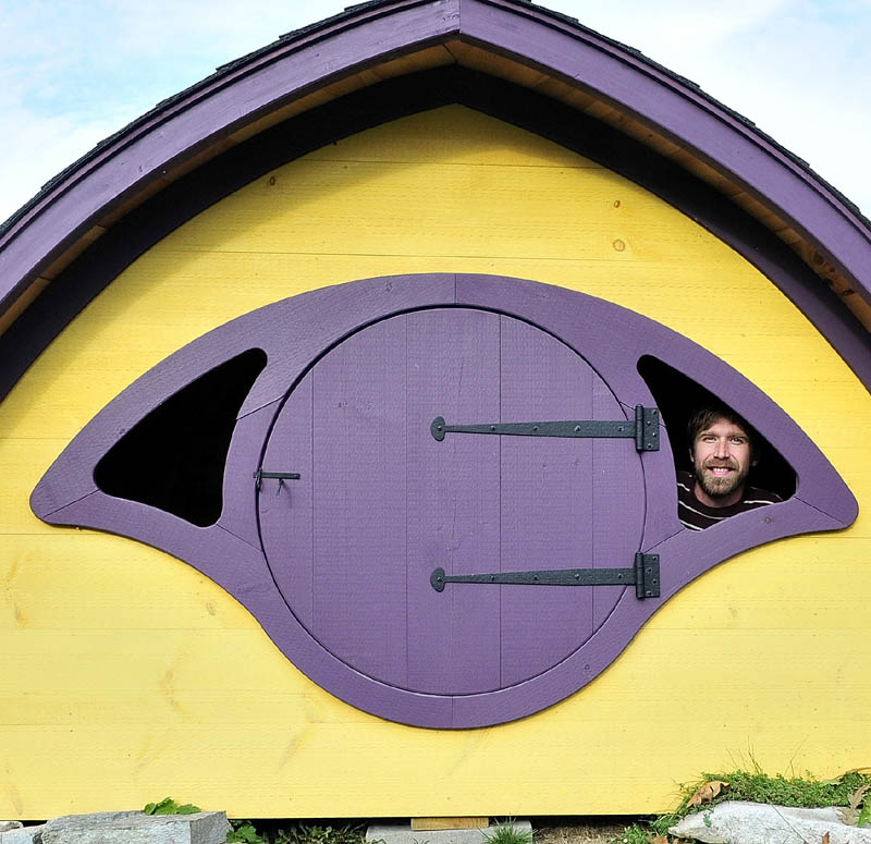 Rocy Pillsbury looks out from the inside of a Hobbit Hole playhouse he builds for his Wooden Wonders business in Unity.