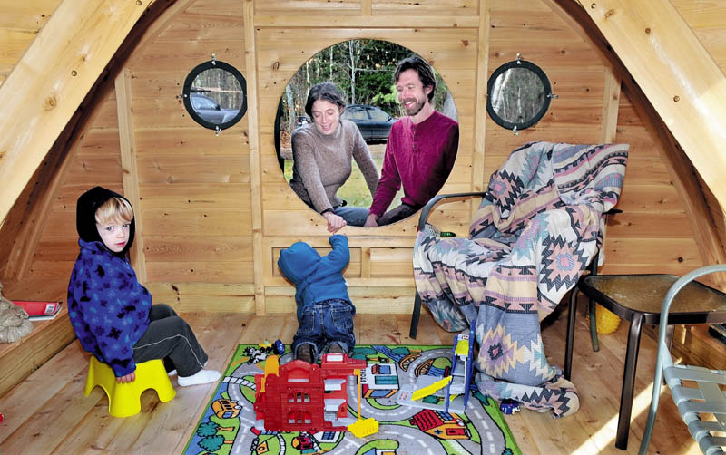Melissa and Rocy Pillsbury watch from a round doorway as their children Richard, left, and Maximus play in one of the Hobbit Hole playhouses they make for their Wooden Wonders business in Unity. The buildings are designed from the J.R.R. Tolkein novels.