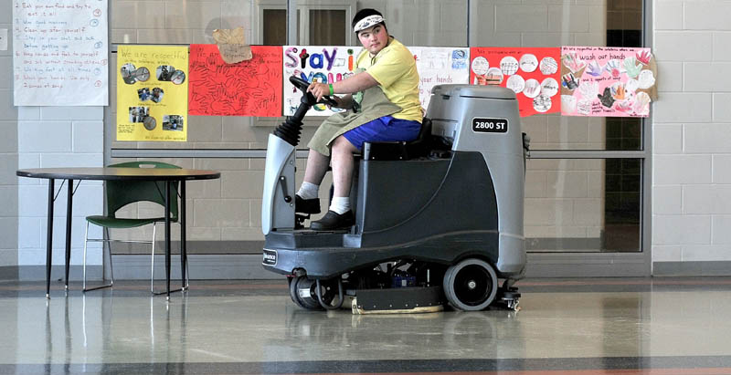 OPPORTUNITY: Mario Montana of Troy operates a riding floor cleaning machine recently in one of the cafeterias at Mount View High School in Thorndike. Montana, 19, has dealt with the challenges of being born with Down syndrome. He graduated last June and is now employed by Regional School Unit 3.