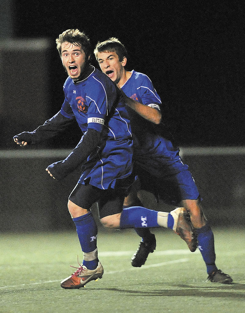 Messalonskee High School's Chris Hall, foreground, celebrates with teammate Billy Blake after scoring the go-ahead goal on a penalty kick against Hampden Academy in the second half in the Eastern Maine Class A boys championship game Wednesday at Hampden Academy. Messalonskee High School won its first Class A championship over Hampden Academy 3-2.