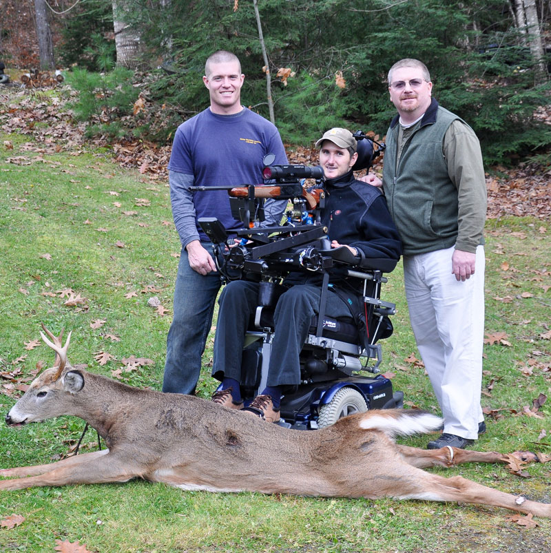 Jeff Molloy, center, poses with a 118-pound four-point buck he shot on Nov. 12 in Albion. With the help of friends Elisha Fowlie, left, and Will Rood, Molloy used a self-designed adaptive shooting system to bag his first deer since a 2004 accident that left him paralyzed from below the chest.