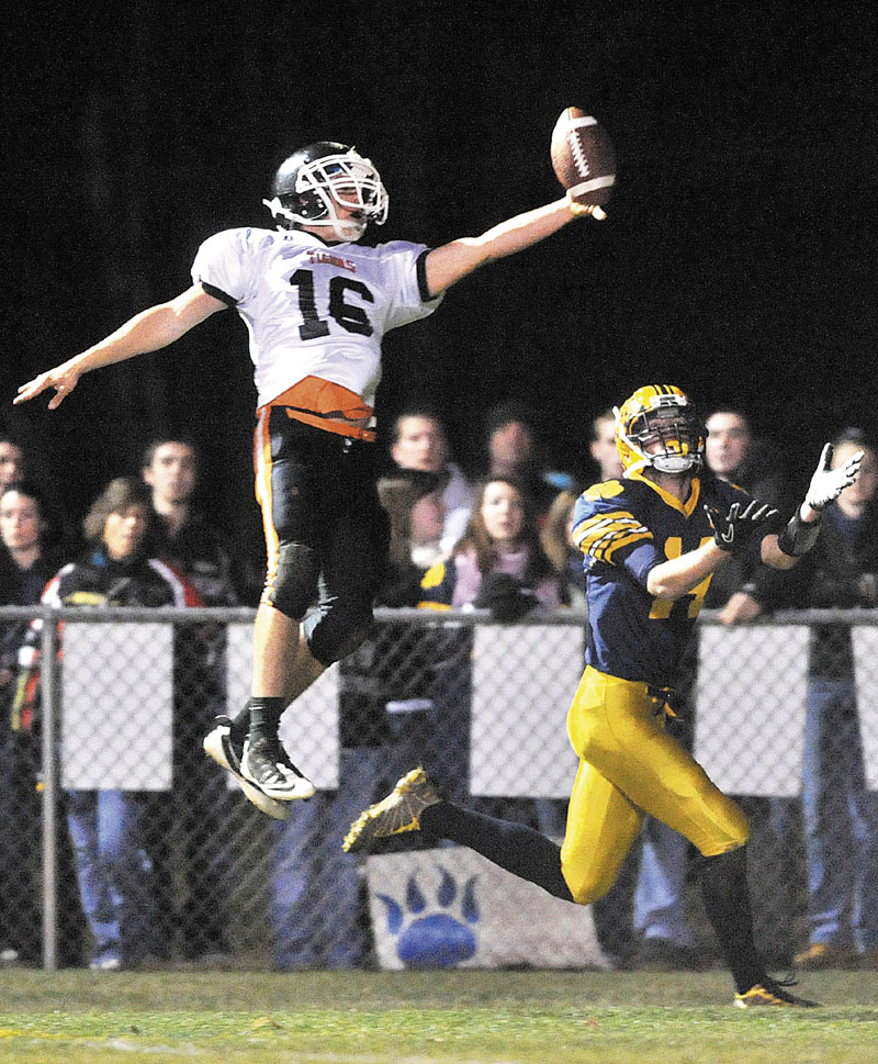 UP, UP and AWAY: Gardiner Area High School’s Matt Hall, left, jumps to break up a pass intended for Mt. Blue High School receiver Cam Sennick, right, in the first quarter Friday night at Kemp Field in Farmington.