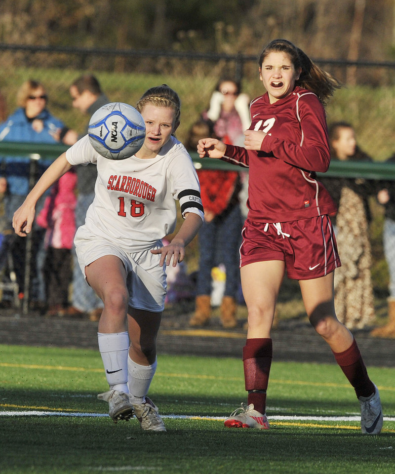 John Ewing/Staff Photographer Haley Carignan, left, of Scarborough sends a shot toward the goal Saturday after slipping past Allison Vanidestine of Bangor in the Class A state final. Bangor won, 4-0.