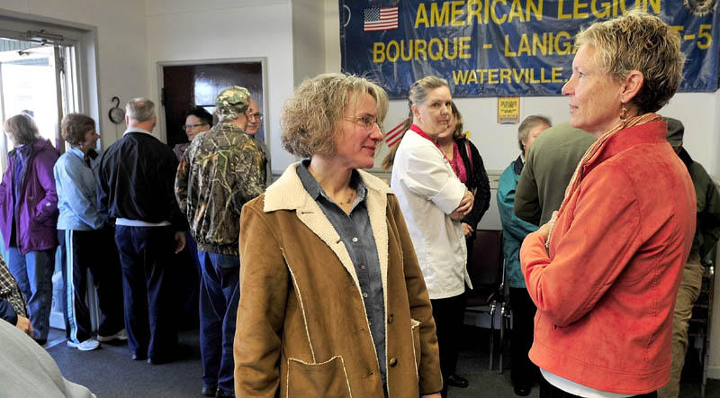 MEET AND GREET: Waterville mayoral candidate Karen Heck, right, speaks with Jill Godfrey prior to polls opening at the American Legion in Waterville on Tuesday. Voters waited in a line that extended outside.
