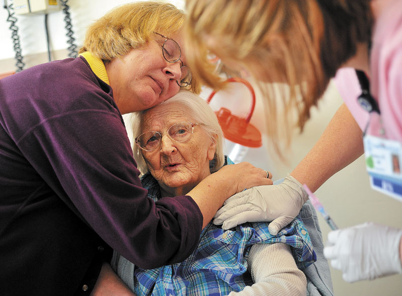 CARE: Cheryl Barkow comforts her mother Alice Osborne as she receives a flu shot from a nurse during a visit to the doctor at Franklin County Memorial Hospital in Farmington last week. Osborne, 93, has dementia.