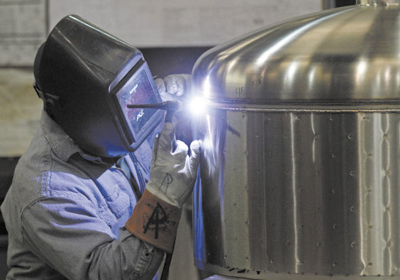 WORKING: Kevin Offield makes a weld on a tank earlier this month at JV Northwest, a manufacturer in Canby, Ore. Jobless claims fell to the lowest level since the spring of 2008, the Labor Department said Thursday.