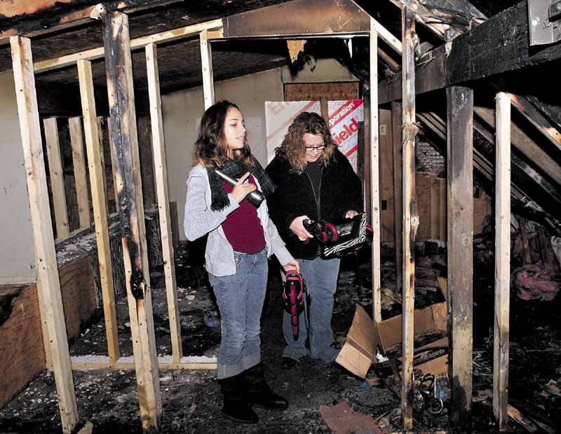 SEARCHING: Lori Fisher, right, and her daughter Adriana on Thursday search for salvageable items in Adriana's bedroom at an apartment building they lived in that was seriously damaged by fire earlier this week in Anson.