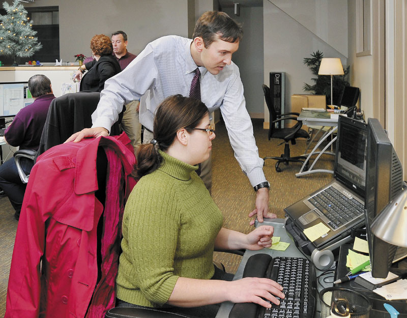 CHANGING CLIMATE: Winxnet CEO Christopher Claudio works with Mandi Emerson Bruce as others work nearby at the fast-growing IT company located in the Intermed Office Building at Marginal and Preble Street in Portland.