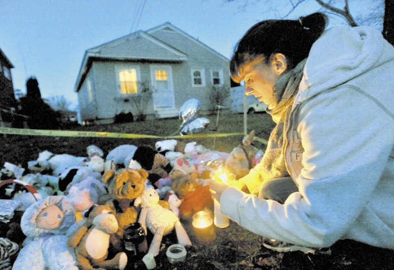 TRIBUTE: Tara True, of Winslow, lights candles at the ever growing teddy bear shrine in front of missing 20-month-old Ayla Reynolds' Waterville home on Wednesday.