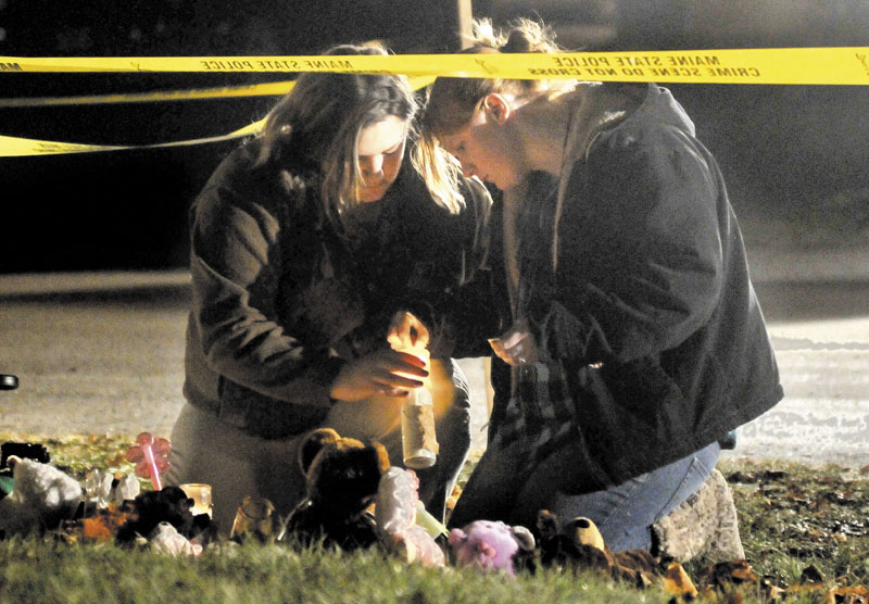 VIGIL: Heather Mirucki, left, and Ashley Tenney, right, light candles at a teddy bear shrine in front of the home of missing girl Ayla Reynolds, below left, on Violette Avenue in Waterville on Thursday night.