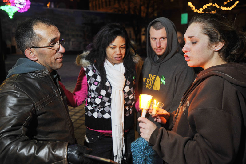 HOPING: Ayla Reynolds’ mother Trista Reynolds, right, is consoled by her father, Ronald Reynolds, left, and her stepsister, Whitney Raynor of Portland, second from left, and her fiance, Charles Martin of Westbrook, at a vigil for the missing girl in Portland’s Congress Square on Friday night.