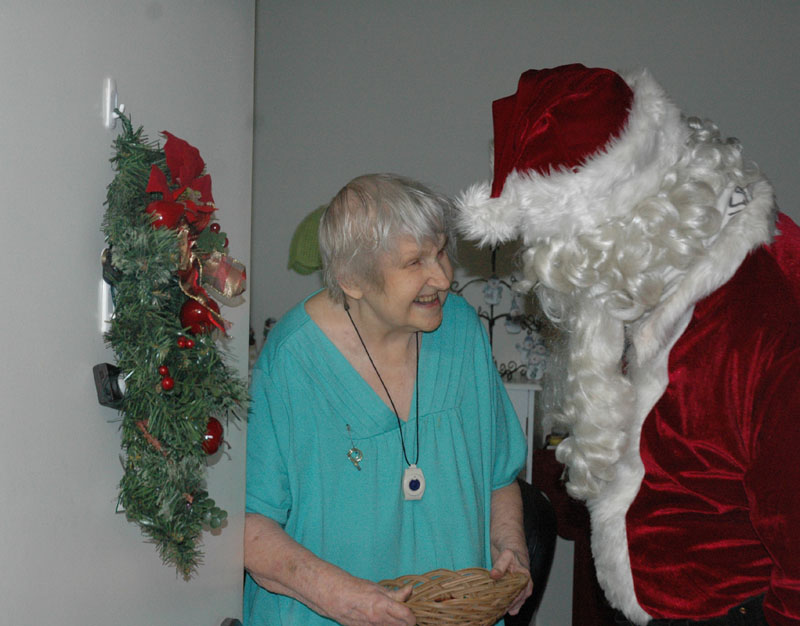 A VISIT FROM ST. NICK: Ann Figar, a resident of Fairmount Circle Drive in Norridgewock, greets Santa with a big smile on Saturday during Santa’s annual pre-Christmas rounds. Firefighter James Gordon has donned the Santa suit to visit the town’s older folks for 25 years.