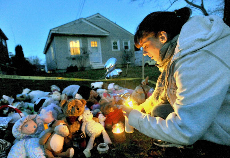 THINKING OF AYLA: Tara True, of Winslow, lights candles at the ever-growing teddy bear shrine for missing 20-month-old Ayla Reynolds in front of her home at 29 Violette Ave. in Waterville.