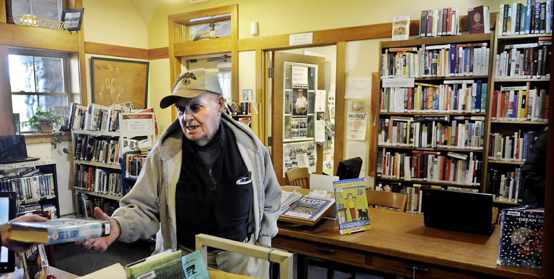 A GOOD BOOK: Belgrade Public Library patron Howard Boston collects a novel Tuesday.