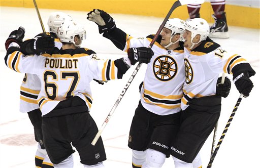 Boston Bruins' Joe Corvo (14), Benoit Pouliot (67) and Chris Kelly, back left, celebrate a game-winning goal scored by Dennis Seidenberg, second from right, during overtime Wednesday against the Phoenix Coyotes in Glendale, Ariz. The Bruins defeated the Coyotes 2-1.