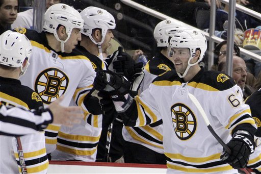 Boston Bruins' Benoit Pouliot (67) celebrates with teammates as he returns to the bench after scoring a second period goal past Pittsburgh Penguins goalie Marc-Andre Fleury on Monday in Pittsburgh.