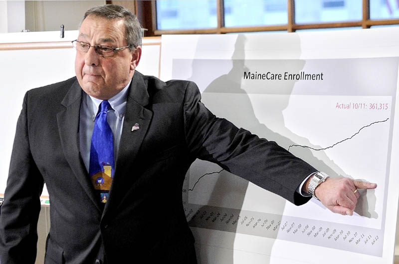 2014 FILE PHOTO: Gov. Paul LePage gestures at a graph during a news conference announcing changes to the MaineCare system Tuesday in Augusta. The graph shows the increasing number of residents on MaineCare, now totaling 361,315.