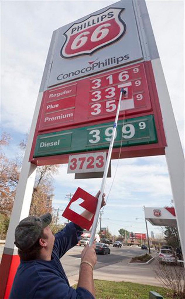 In this Dec. 1, 2011 file photo, store manager Joseph Sublett changes gasoline prices to reflect a three-cent drop at a Little Rock, Ark., Conoco-Phillips station. The U.S. economy is ending 2011 on a roll. Growth in the fourth quarter likely accelerated to the fastest pace since mid-2010, and the job market appears to be strengthening. (AP Photo/Danny Johnston, File)