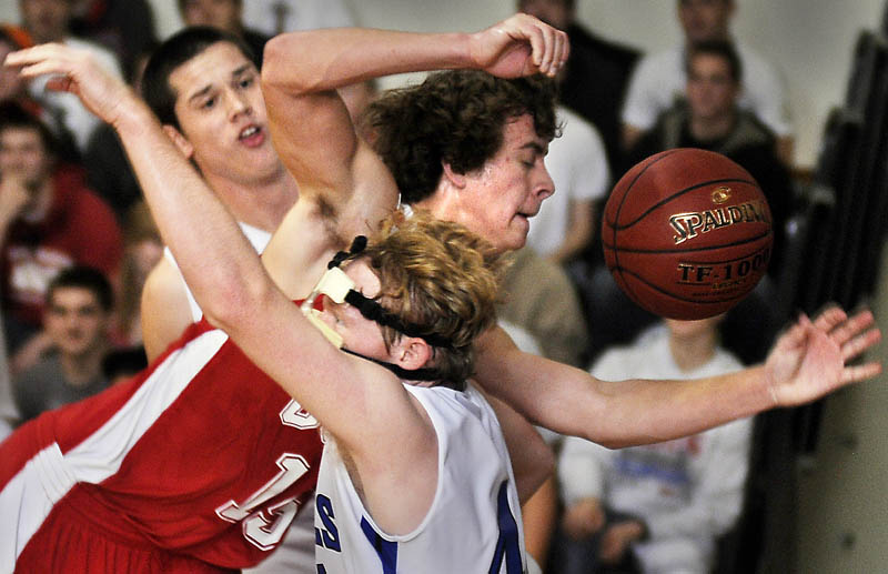 TIGHT SQUEEZE: Cony High School's Josiah Hayward, center, is pinched Thursday between Erskine Academy's Tyler Belanger, right, and Jory Humphrey during a basketball match up in South China.