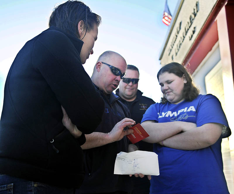Firefighting friends: Winthrop Fire Chief Daniel Brooks, second from left, shows Meg Bateman, 16, right, and her mother, Becky Pottle, left, a gift certificate for dinner along with an envelope containing more than $1,000 that the department donated to them Monday after their Winthrop home burned last week. Josh Wheeler, second from right, and his students at the Mid-Maine Tech Center in Waterville also gave Bateman $400.00 to replace items she lost in the blaze. Batemen is a junior firefighter in Winthrop and enrolled in a course taught by Wheeler.