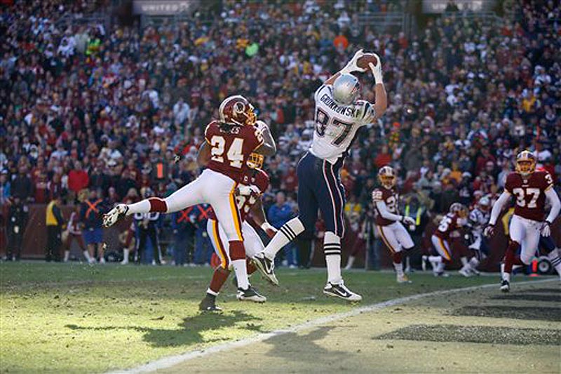 New England Patriots tight end Rob Gronkowski (87) catches a touchdown pass over Washington Redskins strong safety DeJon Gomes (24) during the first half of an NFL football game on Sunday, Dec. 11, 2011 in Landover, Md. (AP Photo/Evan Vucci)