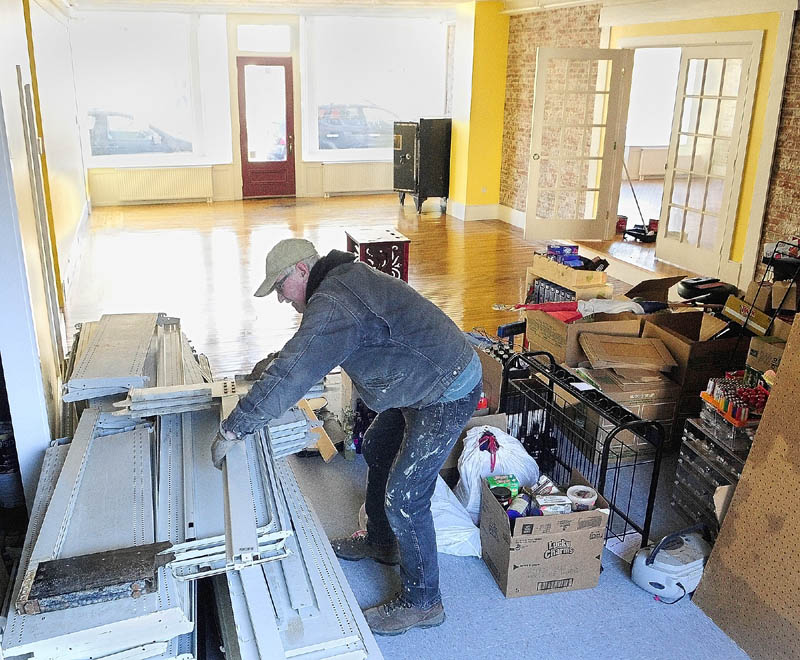 Donald Lachance carries shelves into the Water Street storefront where he and his wife plan to open a new Boynton’s Market in Hallowell.